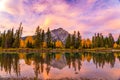 Banff National Park beautiful scenery. Fiery pink clouds, Cascade Mountain, colorful trees reflected on Bow River in autumn Royalty Free Stock Photo