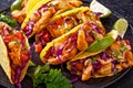 Bang Bang Shrimp Tacos on black plate with sauce