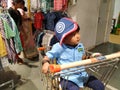 Indian Blue Shirt Wear little Kid in a Big Bazaar Sitting in a Trolley with Cap