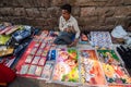 An Indian street vendor selling colorful posters, cards and artwork on a sidewalkin