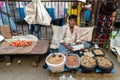 An Indian street vendor selling spices on the footpath in the KR Market area of the