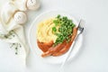 Bangers and mash. Grilled sausages with mash potato and green pea on white plate on light background. Traditional dish of Great Br Royalty Free Stock Photo