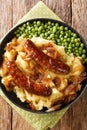 Bangers and Mash With Onion Gravy closeup in the plate. Vertical top view Royalty Free Stock Photo