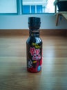 Samyang Buldak Korean hot sauce in black bottle on a wooden floor