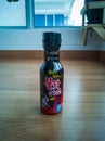 Samyang Buldak Korean hot sauce in black bottle on a wooden floor