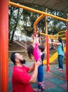 Child on monkey bars with father. Little girl hanging on gym play ground. Healthy outdoor Royalty Free Stock Photo