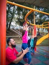 Child on monkey bars with father. Little girl hanging on gym play ground. Healthy outdoor Royalty Free Stock Photo