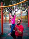 Child on monkey bars with father. Little girl hanging on gym play ground. Healthy outdoor Royalty Free Stock Photo