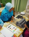 Colourful letters on the book as reference for the child to type into the braille typwriter