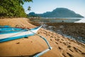 Bangka banca boat on sandy remote beach lit by golden sunset light. El Nido village in background. Philippines Royalty Free Stock Photo