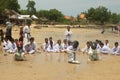 A group of children playing a sack race with helmet on (balap karung dengan helm), in Tlangoh beach.