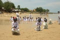 A group of children playing a sack race with helmet on (balap karung dengan helm), in Tlangoh beach.