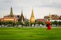 Bangkok, Bhuddist monk walking in Sanam Luang park with Wat Phra Kaeo