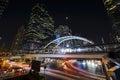 Bangkok business center at night with car light trails, skywalk and building