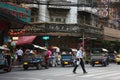 Bangkok Chinatown. Movement of transport. A man crosses the road. Middle ground