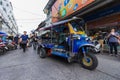 BANGKOK - JANUARY 16, 2017: A three-wheeled tuk tuk taxi drives along a road in Klongthom Market Bangkok, Thailand.