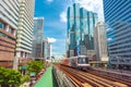 Bangkok, Thailand: a BTS train travels between the downtown `s skyscrapers against the blue sky Royalty Free Stock Photo