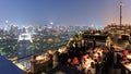 Bangkok by night viewed from a roof top bar with many tourists enjoying the scene Royalty Free Stock Photo