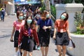 Bangkok people in medical masks walk through the city.