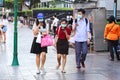 Bangkok people in medical masks walk through the city.