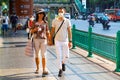 Bangkok people in medical masks are walking along the street of the city.