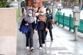 Bangkok people in medical masks are walking along the street of the city.