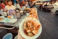 Bangkok street food court and small plate with spring rolls in hand of hungry customer. Asian snacks in time for lunch Royalty Free Stock Photo