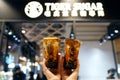 BANGKOK, THAILAND - APRIL 4, 2019: Bubble Milk Tea - Holding plastic glass of fresh milk with black sugar syrup.