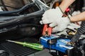 BANGKOK,THAILAND -24 April 2022 :Mechanic charging car battery with battery jumper cable in garage.