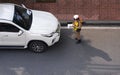 Top view of Asian policeman writing traffic ticket for white car that parked in prohibited parking area on the road Royalty Free Stock Photo