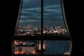 The beautiful view of Bangkok, the beautiful skyscrapers along the Chao Phraya River during sunset seen through a bedroom window. Royalty Free Stock Photo