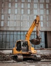 A construction excavator of yellow color is parked in front of the building construction site Royalty Free Stock Photo