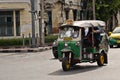 Bangkok Thailand, 20 august 2017. Green auto rickshaw Tuk Tuk with driver in traffic on streets of Asian metropolis Bangkok