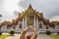 Bangkok, Thailand - 30 August 2020: hand holding thai 5 baht coin with blur traditional classic thai temple as a background Royalty Free Stock Photo