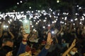 Protesters a three finger salute with flash light to show symbolic gestures.