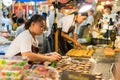 Bangkok, Thailand - August 5, 2017: Thai female candy vendor making fresh Thai dessert, its name is `Pang Gi` Coconut Pancake.