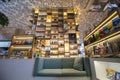 Bangkok, Thailand - August 7, 2020: trendy and modern bookstore high bookshelf with green sofa lights painting leaves on ceiling