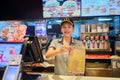 Bangkok, Thailand - Dec 3, 2019: Young part-time student workers smiling while handing McDonald`s Brown Bag to customer at McDonal