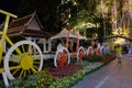 Decorative bicycles adorn the flowerbed on a city street. A man in a yellow T-shirt is