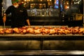 Bangkok, Thailand - December 25, 2019: Food vendor preparing chicken on a spit in a Bangkok market