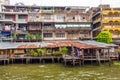 Wooden slums on stilts on the riverside of Chao Praya River in Bangkok Royalty Free Stock Photo