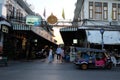 Several young people strolling along the street of an Asian city in the evening. A brightly