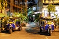 Tuk-tuk, an auto rickshaw. Little Asian taxis stand on a city street at night