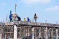 BANGKOK, THAILAND - DECEMBER 23: Unidentified construction workers works with cement lifted from a crane on the roof of Chao Sua