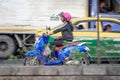BANGKOK, THAILAND - DECEMBER 15: Unidentified female on Honda Scoopy i Club 12 scooter commutes on Petchkasem 69 in Bangkok on