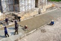 BANGKOK, THAILAND - DECEMBER 19: Unidentified group of contruction workers flatten cement at the construction site of Chao Sua 69