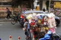 Woman pull cart where is many stuffed toys.