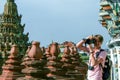 European tourist holding camera by his eyes. Portrait of a guy shooting a camera man.