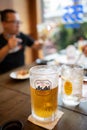 Cold Asahi beer mug on a dark brown wooden table in a Japanese izakaya restaurant