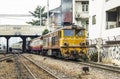 Train is departing from origin bangkok station through commercial building shabby.